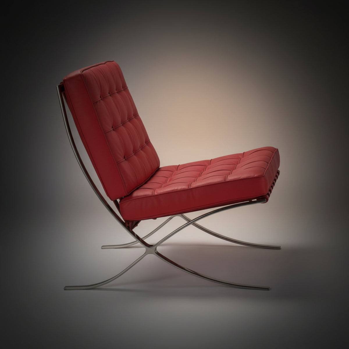 A modern red tufted leather armchair with a chrome curved metal frame, shown from a side profile