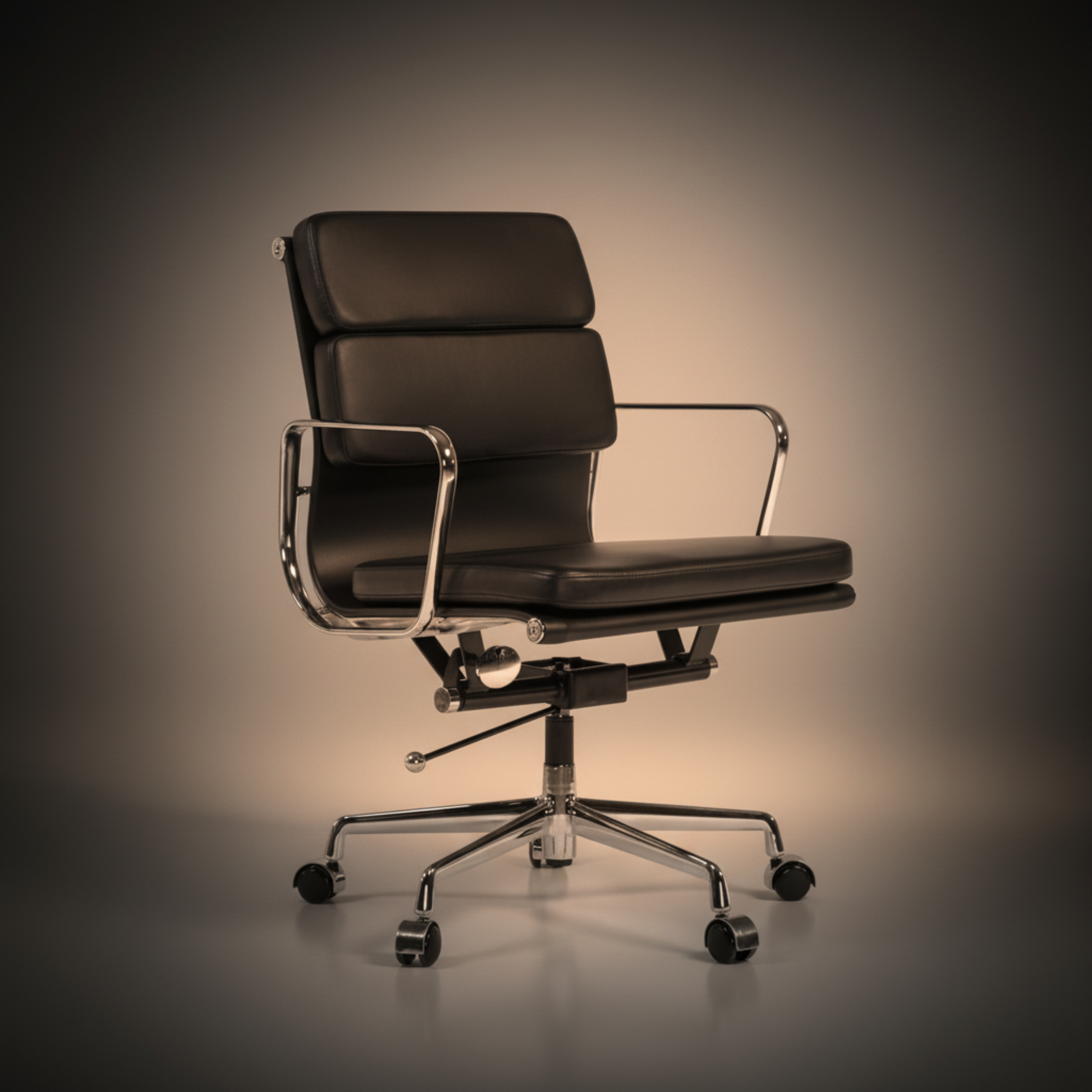 A modern black leather office chair with chrome metal armrests and a five-star wheeled base