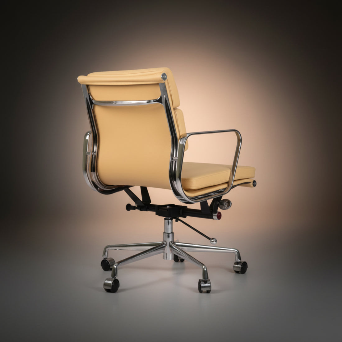 A modern office chair with cream-colored leather upholstery and a polished chrome five-star base