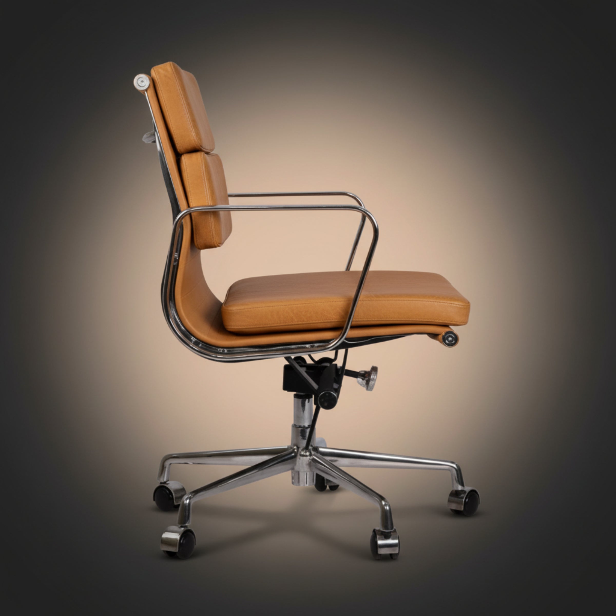 A modern high-back office chair with tan leather upholstery and a chrome metal frame, base, and five-wheel casters