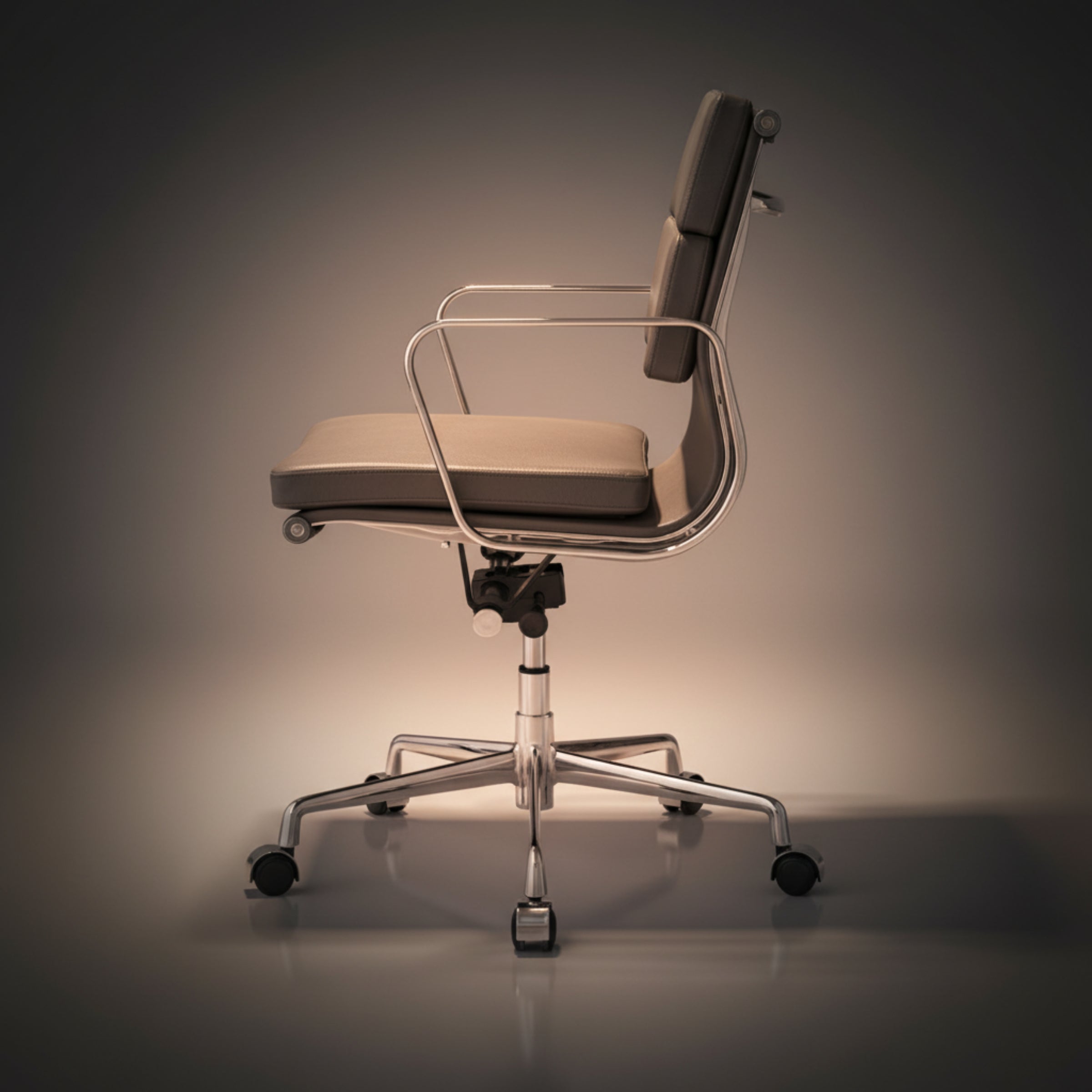 A modern office chair with a beige upholstered seat and backrest, a clear curved metal arm frame
