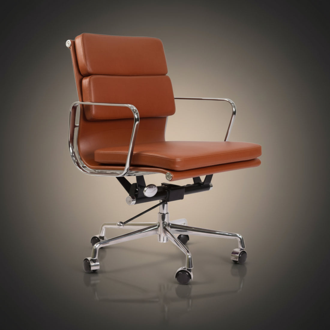 A modern office chair with tan leather upholstery and a polished chrome metal frame, base, and casters