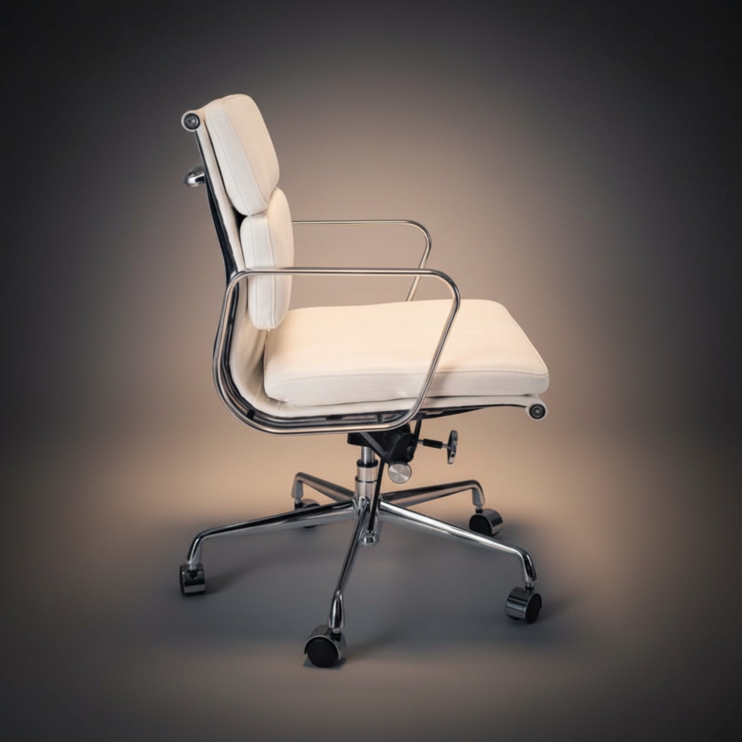 A modern office chair with cream-colored padded upholstery and a polished chrome metal frame