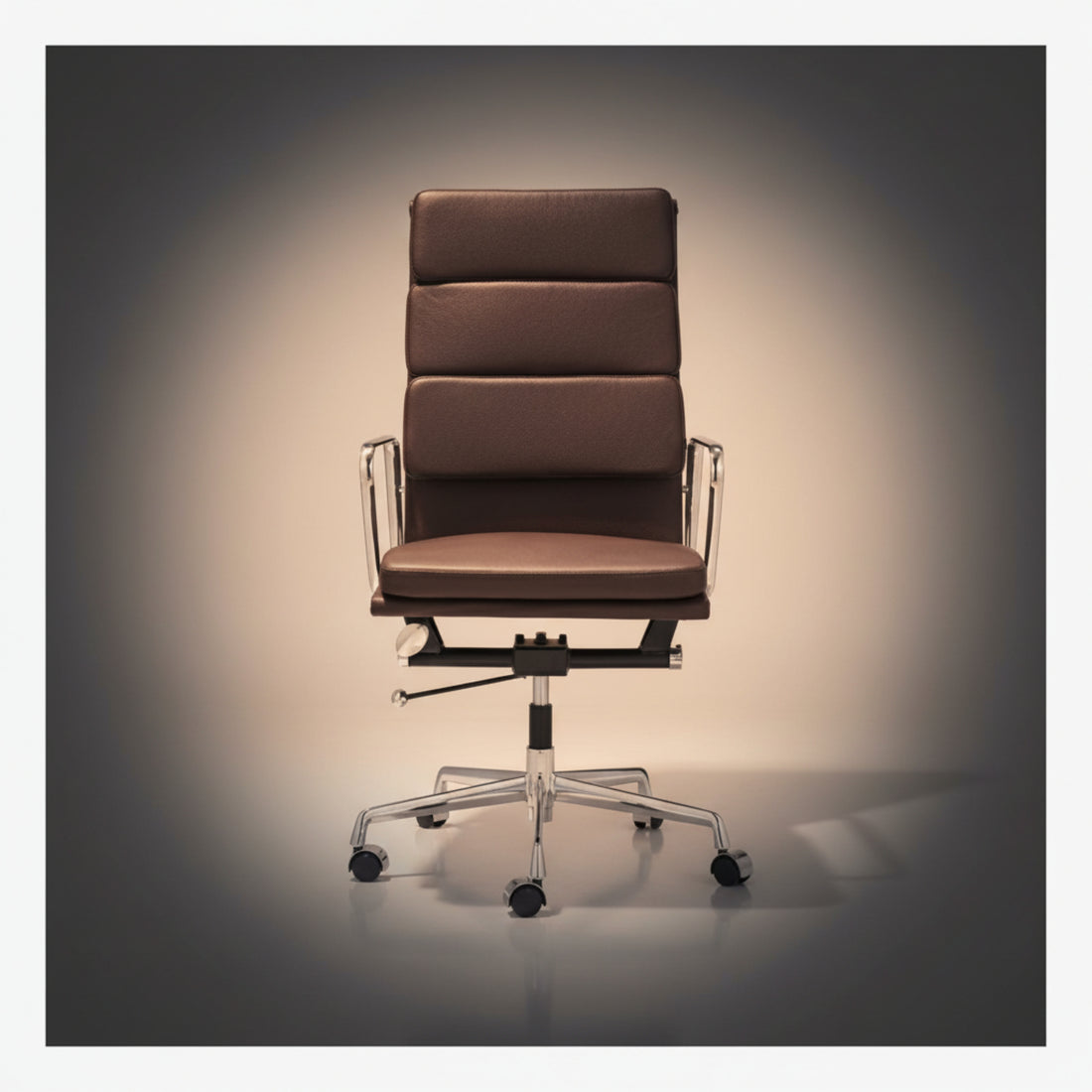 A modern high-back office chair with brown padded upholstery and a chrome five-star base, photographed against a dark gradient studio background.