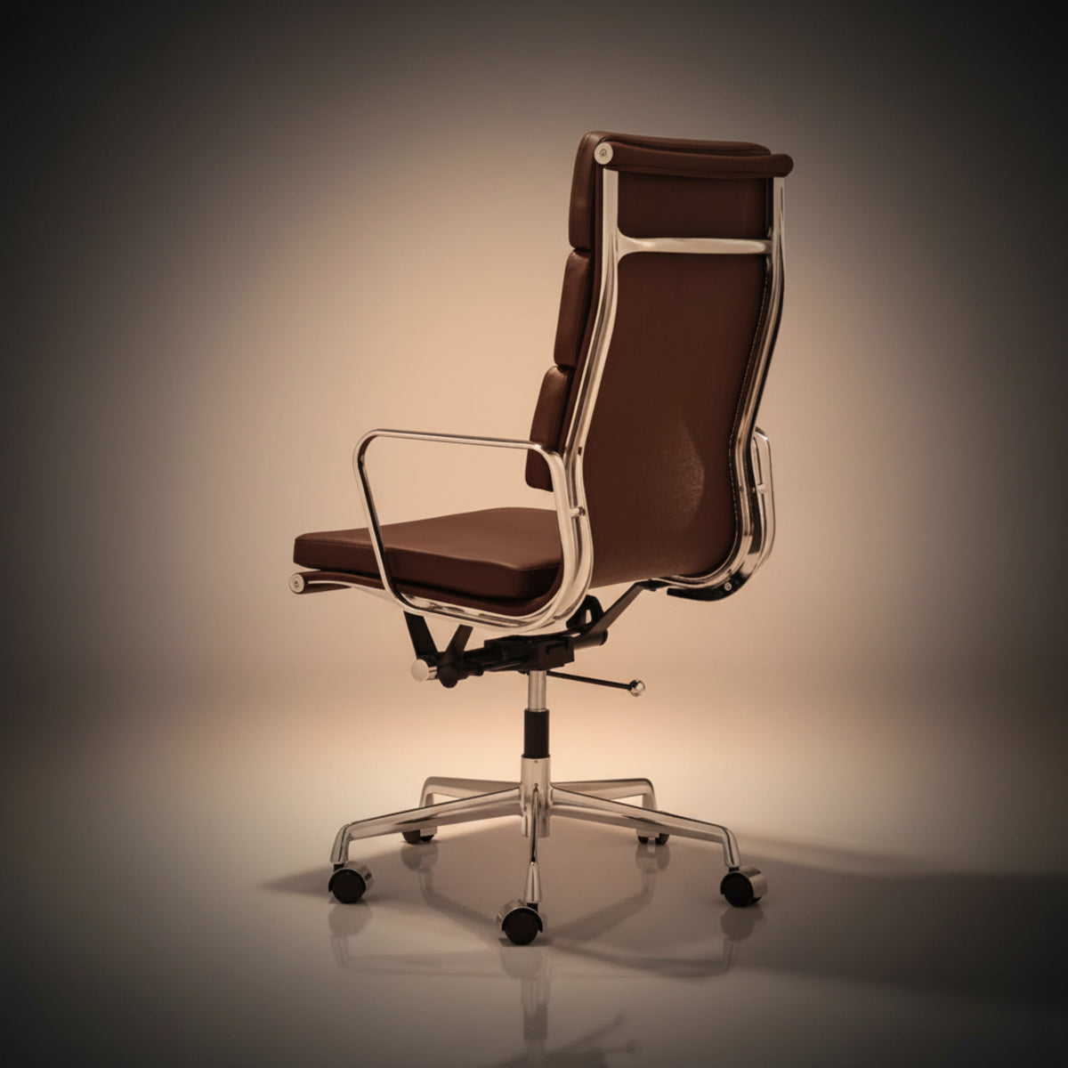 A modern high-back office chair with brown leather upholstery and a polished chrome metal frame, base, and five-wheel casters