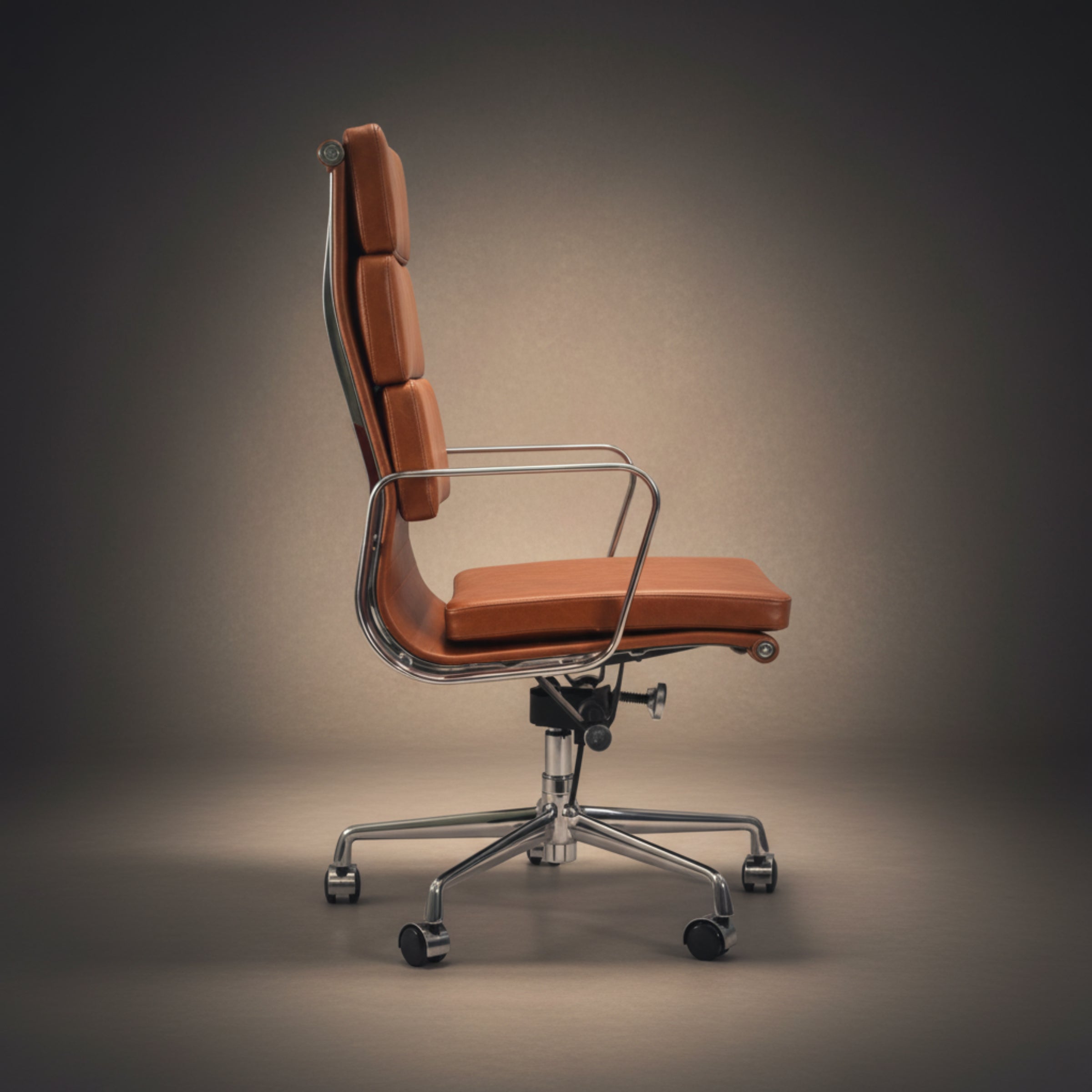 A modern high-back office chair with orange-brown leather upholstery and a chrome five-star base, shown against a dark gray studio background.