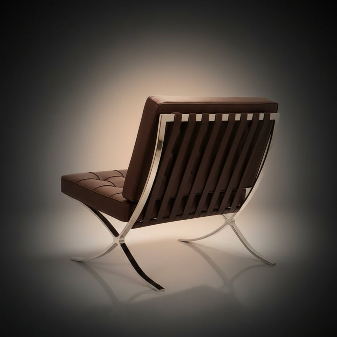 A modern tufted leather armchair with a dark brown cushioned seat and backrest, supported by a chrome X-frame base