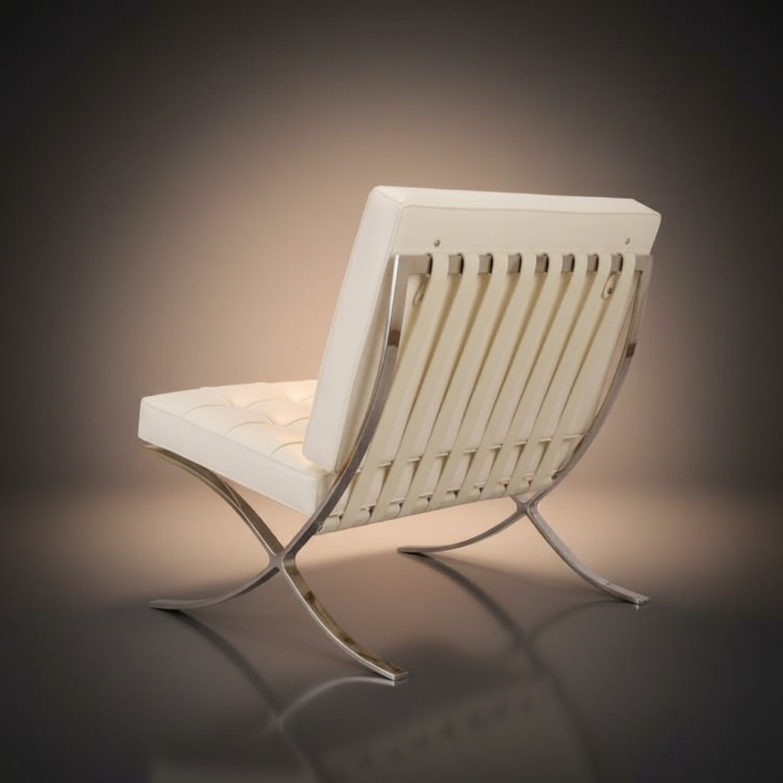 A modern tufted leather armchair with a chrome metal frame, shown on a dark gray reflective studio