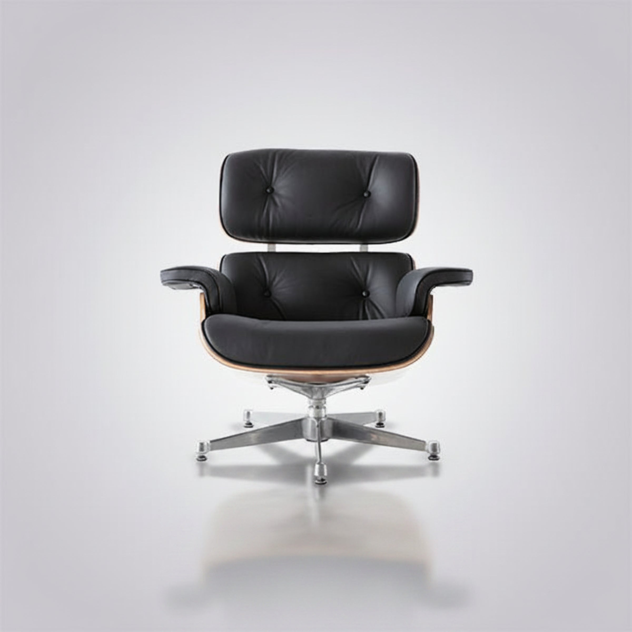 A classic mid-century modern lounge chair with black leather upholstery, a curved wooden frame