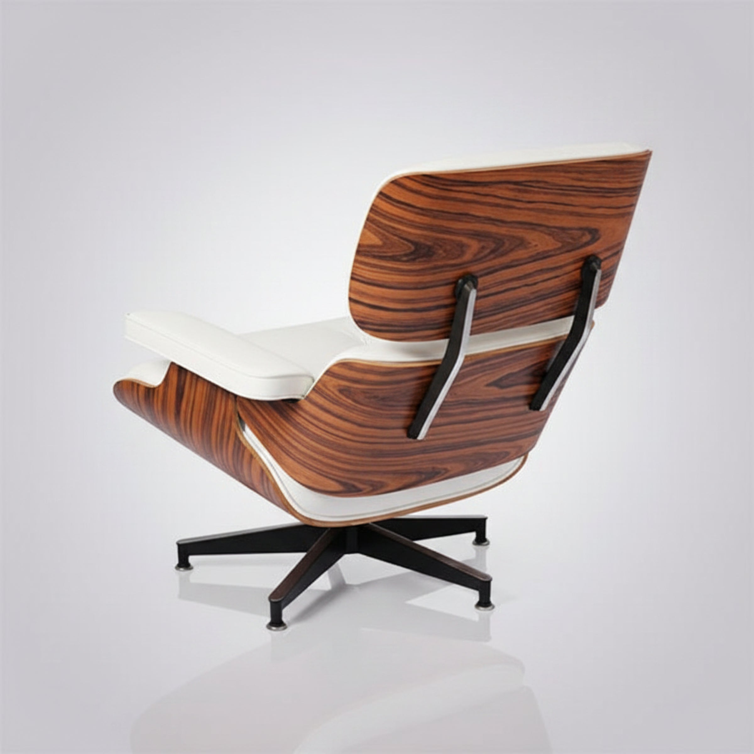 A mid-century modern lounge chair with a dark brown wood grain shell, white leather cushions