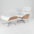 A modern lounge chair with a matching ottoman, featuring white leather upholstery, light wood grain sides