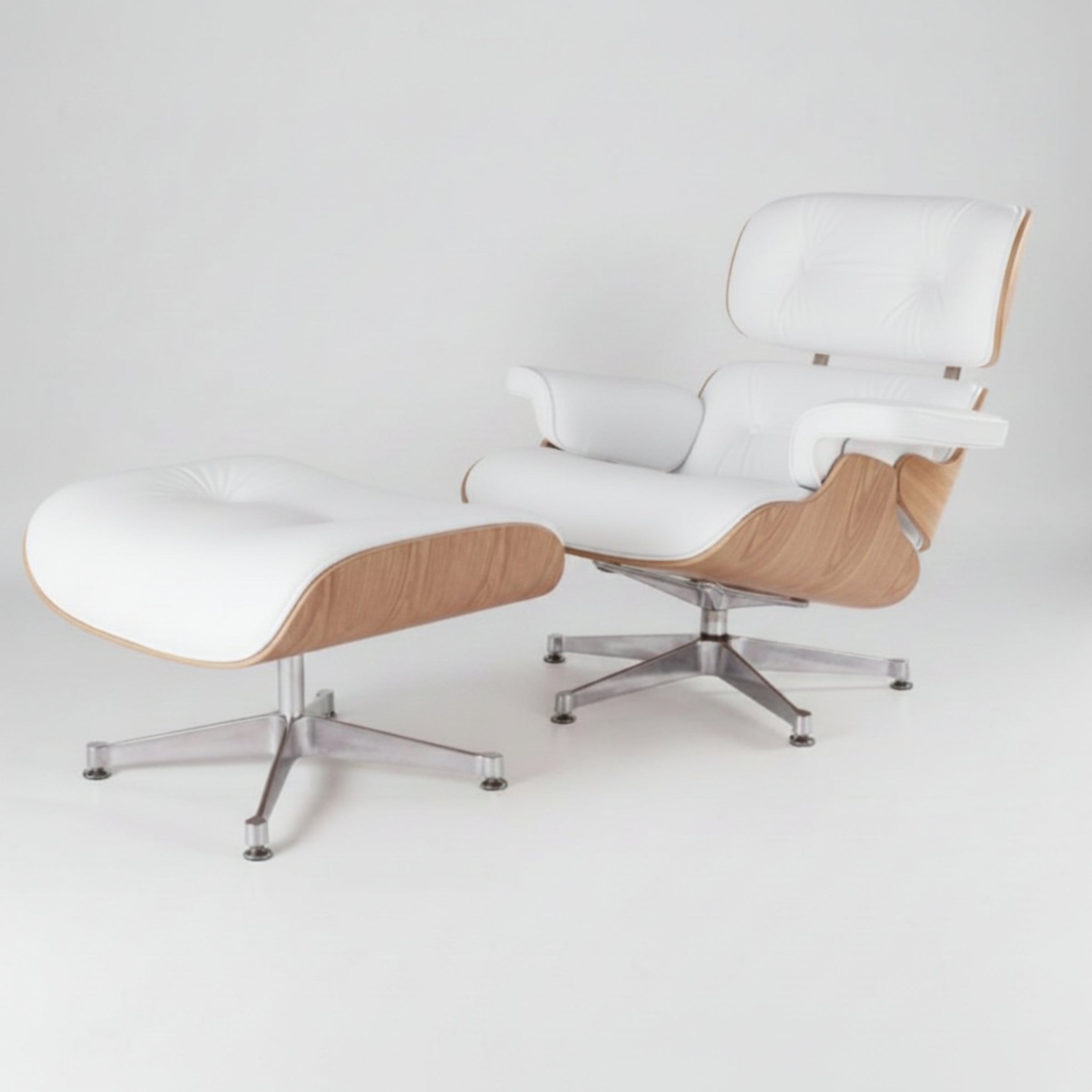 A modern lounge chair with a matching ottoman, featuring white leather upholstery, light wood grain sides