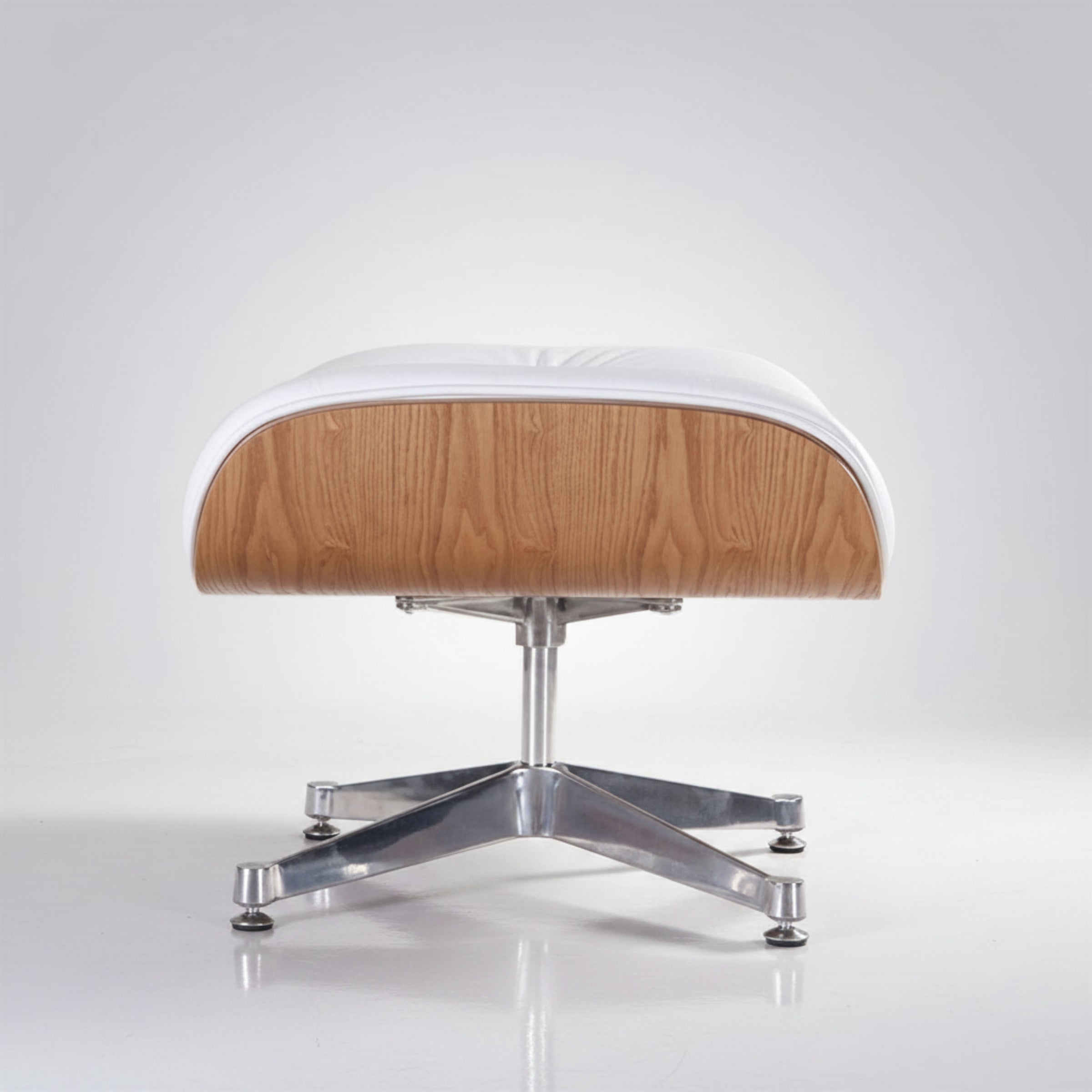 A modern lounge ottoman with a white leather cushion, a light oak wood veneer backrest, and a chrome metal four-star base
