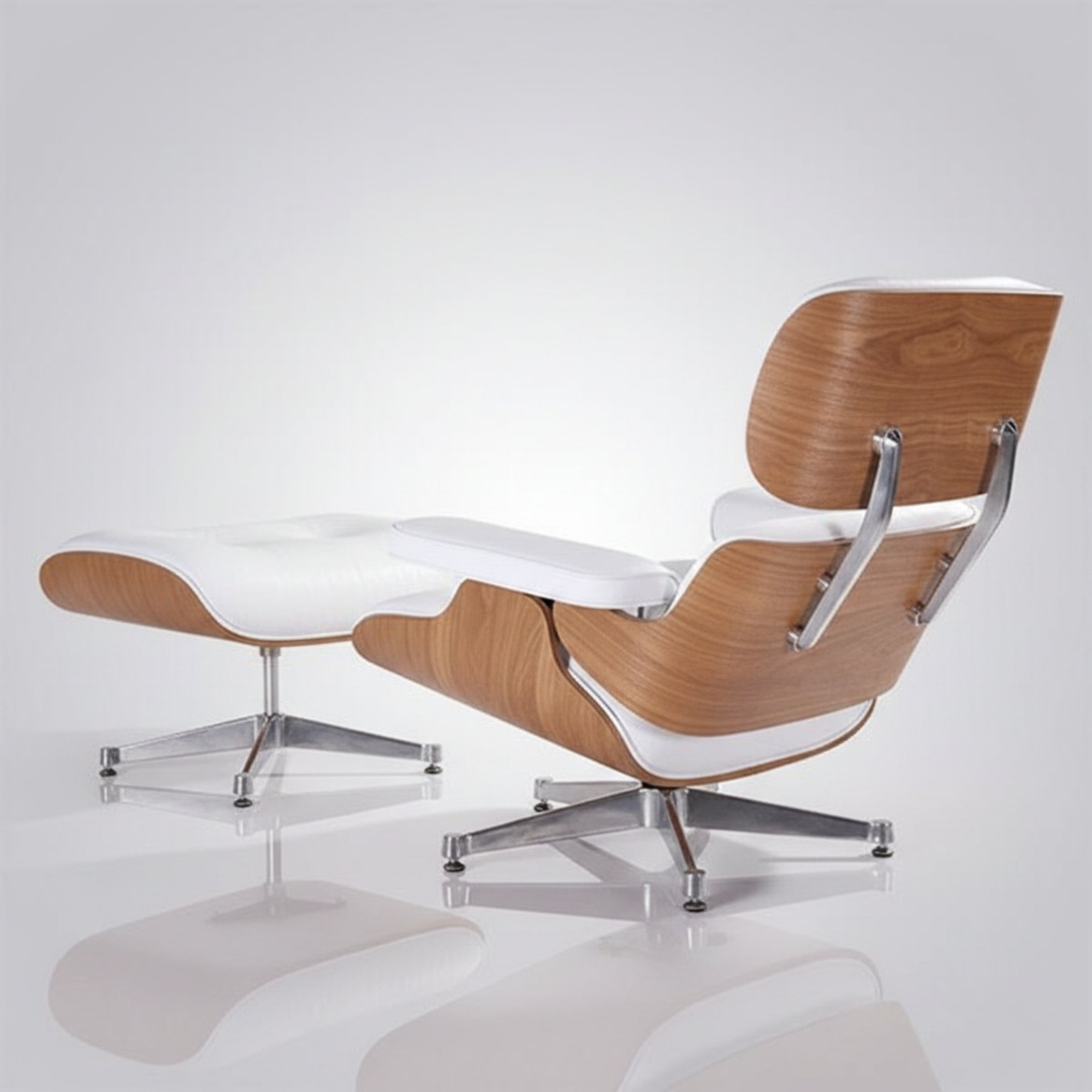 Modern lounge chair with matching ottoman in white leather and natural wood shell, supported by chrome star bases