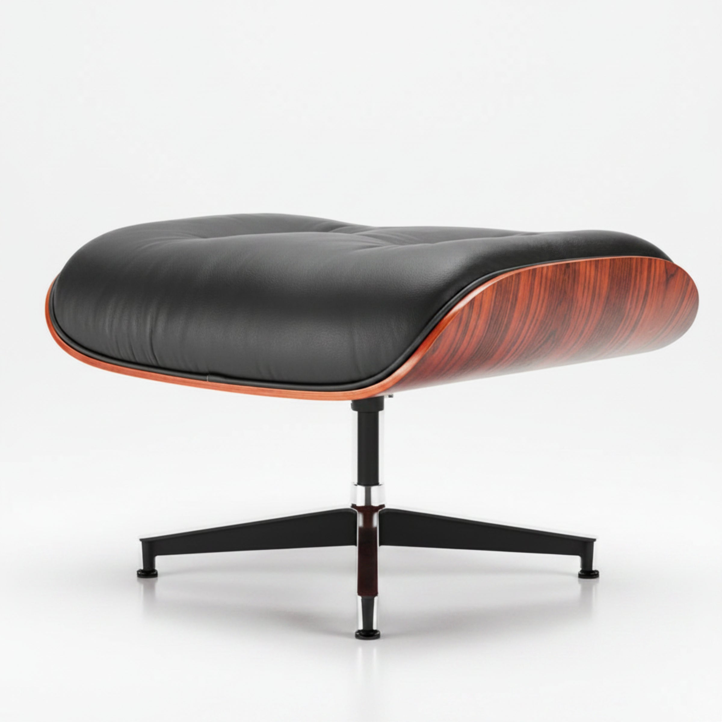 A modern lounge ottoman with a black tufted leather cushion, a curved reddish-brown wood veneer side