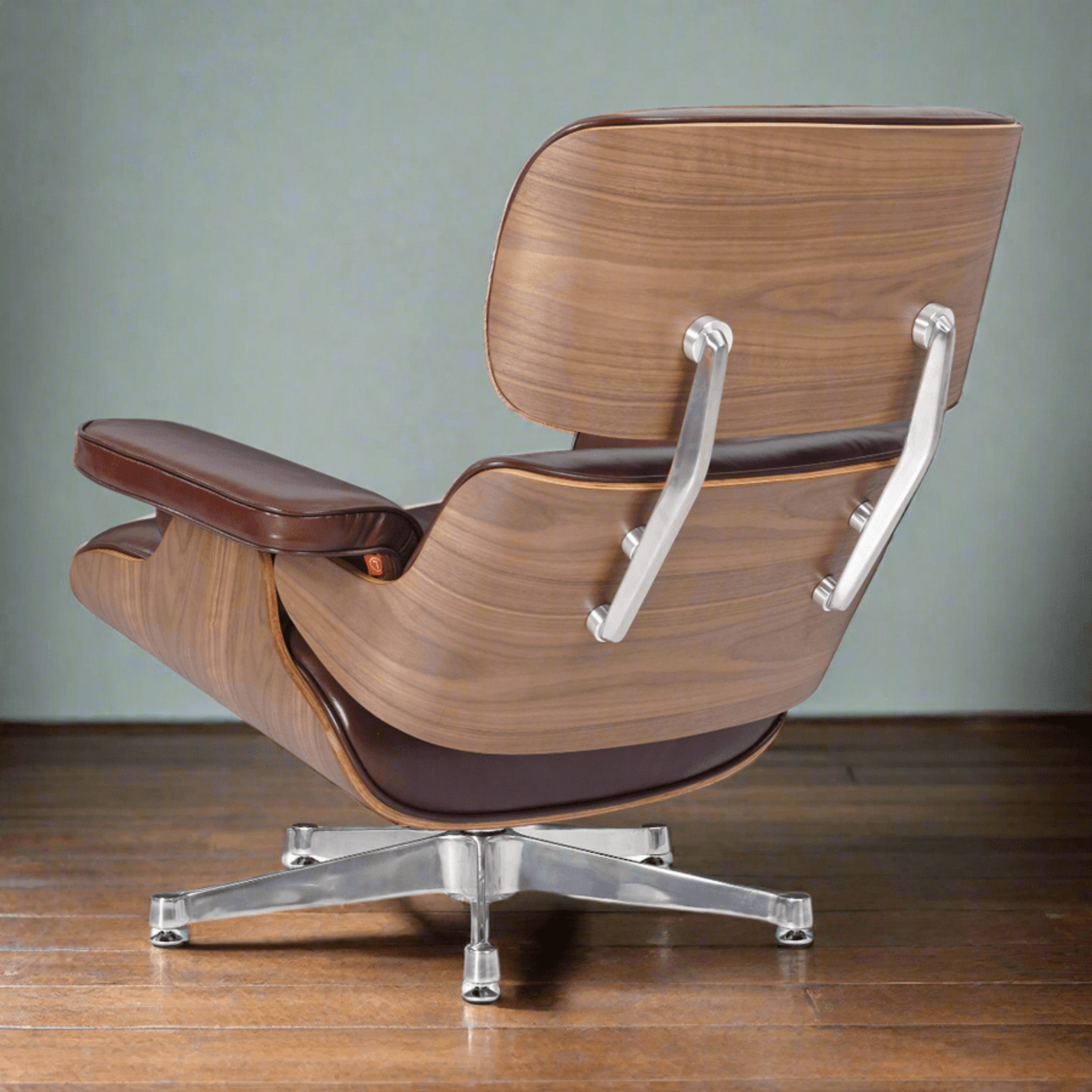 A classic mid-century modern lounge chair with a curved wooden shell, dark brown leather upholstery