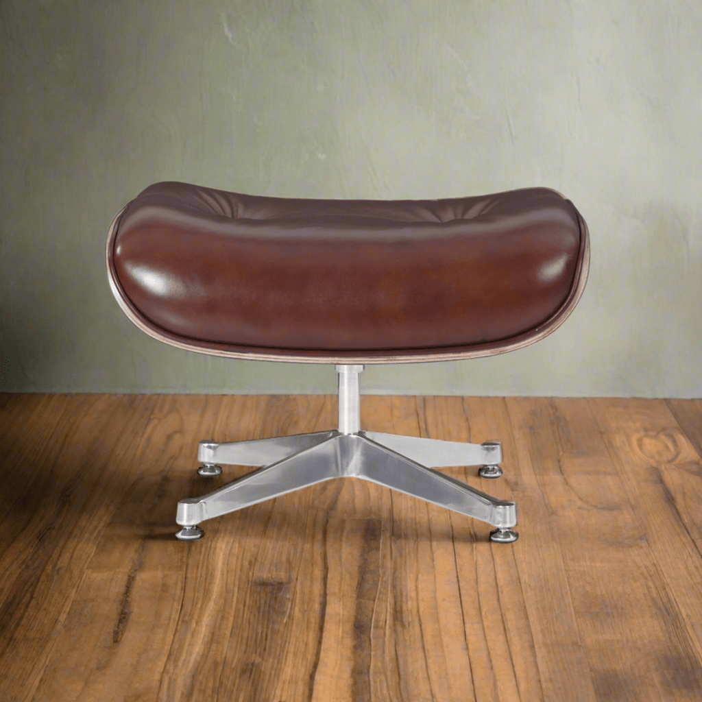 Brown leather chair with metal base on a wooden floor against a green wall