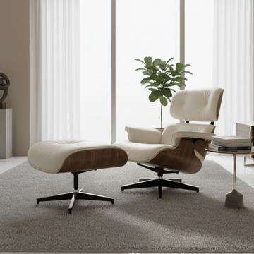 Modern lounge chair and ottoman in a room with large windows and a plant.